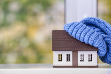 Evin şekli ve pencere pervazında sıcak bir şapka. Isınma mevsimi kavramı