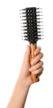 Beyaz arka planda kadın eli ve yuvarlak saç fırçası