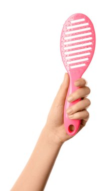 Beyaz arka planda kadın eli ve saç fırçası