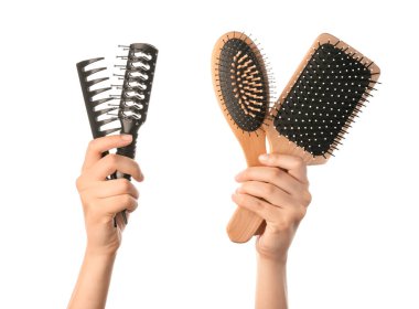 Beyaz arka planda kadın elleri ve saç fırçaları