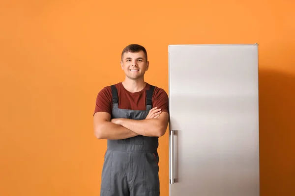 色の背景に冷蔵庫の近くの修理サービスの労働者 — ストック写真