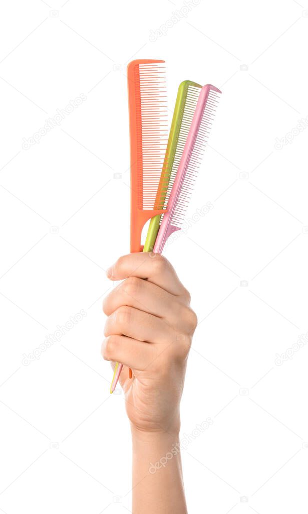 Woman hand and hair combs on white background