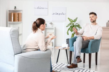 Ofiste genç bir kadınla çalışan erkek psikolog.