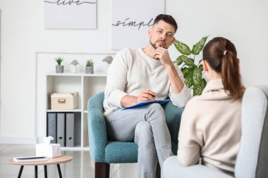 Ofiste genç bir kadınla çalışan erkek psikolog.