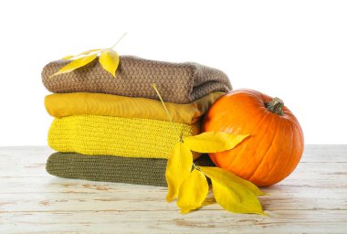 Masadaki sonbahar kıyafetlerini beyaz arkaplana karşı stil et