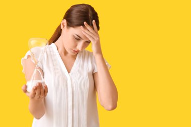 Renkli kum saati olan depresif bir genç kadın.