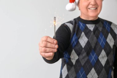 Işık arka planında Noel havai fişekleri olan son sınıf öğrencisi.