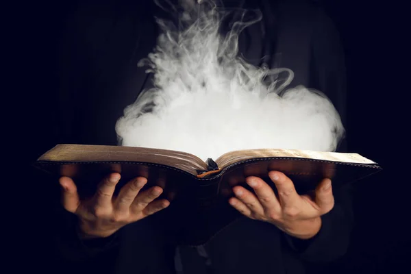 Woman with magic book on dark background