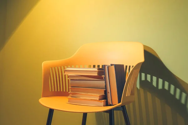 カラーウォールの近くの本と椅子 — ストック写真