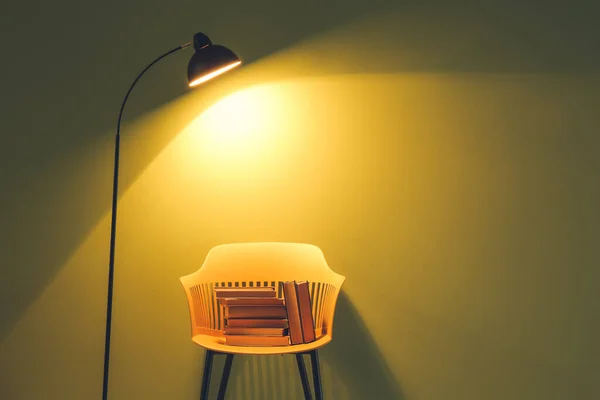 Krzesło Książkami Lampą Pobliżu Ściany Koloru — Zdjęcie stockowe