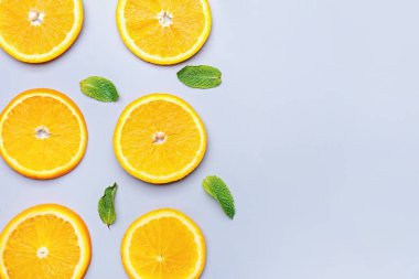 Gri arkaplanda naneli portakal meyvesi dilimleri