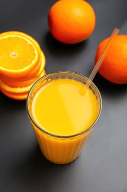 Koyu arkaplanda bir bardak portakal meyvesi