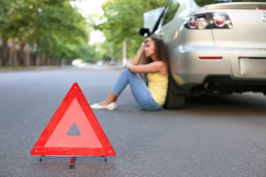 Acil dur levhası ve dışarıdaki kırık arabanın yanındaki Afro-Amerikan kadını strese soktu.