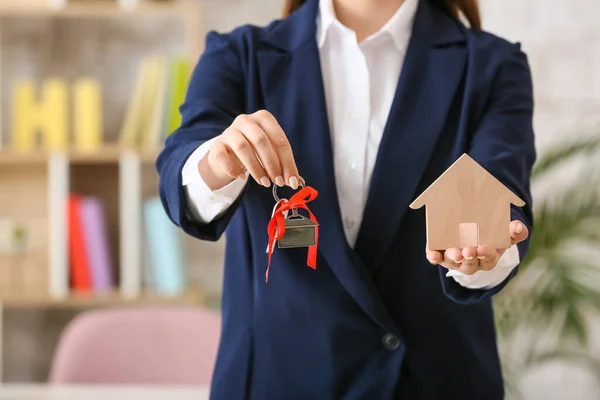 Real estate agent with key from house in office, closeup