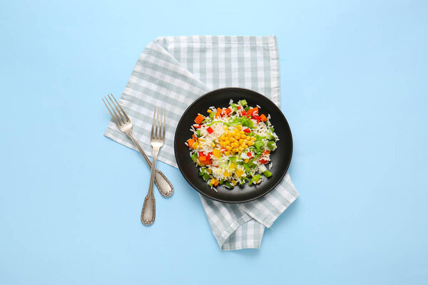 Plate of delicious rice salad with vegetables on color background