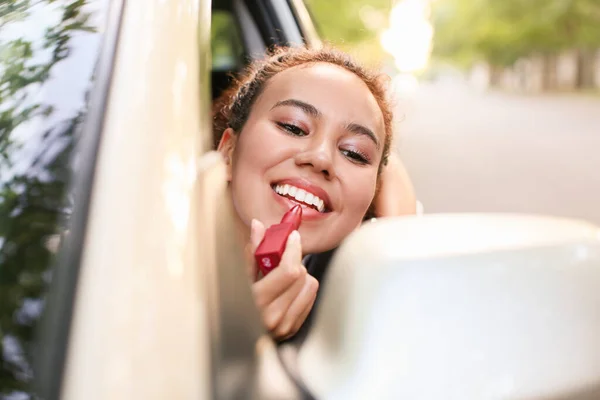 Piękna Afroamerykanka Szminka Podczas Siedzenia Samochodzie — Zdjęcie stockowe