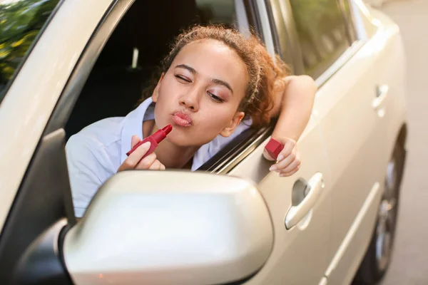 Beautiful African American Woman Applying Lipstick While Sitting Car — Stock Photo, Image