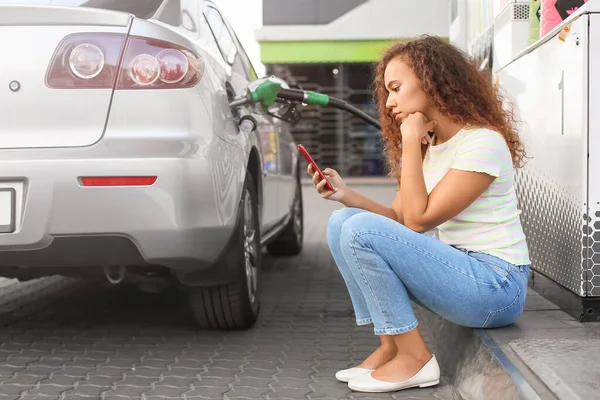 ガソリンスタンドで車のタンクを満たすアフリカ系アメリカ人女性 — ストック写真
