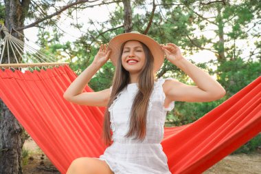 Hamakta dinlenen genç ve güzel bir kadın.