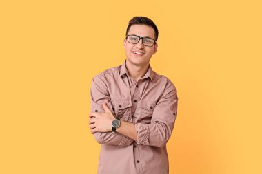 Renkli arka planda kol saati olan genç adam.