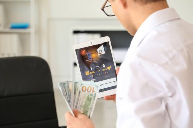 Genç işadamı spor bahislerini ofise koyuyor.