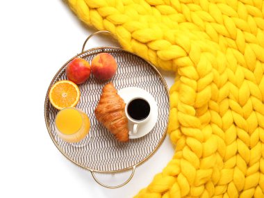 Lezzetli kahvaltı tepsisi ve beyaz arka planda ekose örgü.