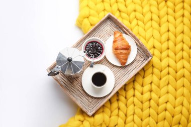 Lezzetli kahvaltı tepsisi ve beyaz arka planda ekose örgü.