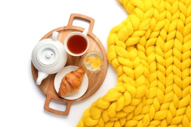 Lezzetli kahvaltı tepsisi ve beyaz arka planda ekose örgü.