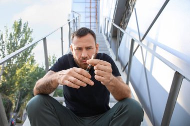 Açık havada uyuşturucu bağımlısı bir erkek. Bağımlılık kavramı