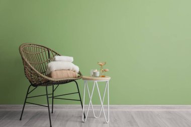 Elbiseli koltuk ve odanın içinde yanan mumlar olan masa.