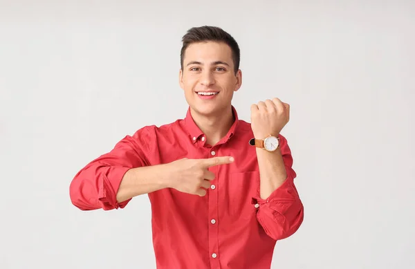 ライトを背景に腕時計を持つ若い男 — ストック写真