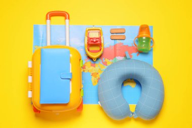 Bavul ve çocuk aksesuarlarıyla renklendirilmiş düz kompozisyon. Seyahat kavramı