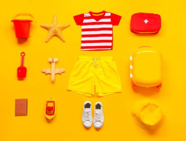 Küçük çocuk plaj aksesuarları ve ilk yardım çantasıyla renklendirilmiş düz kompozisyon. Seyahat kavramı