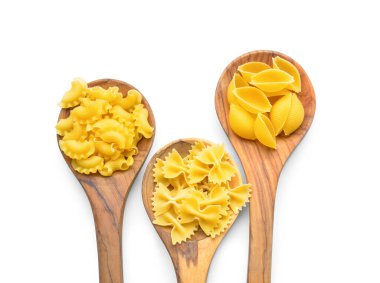 Beyaz arka planda farklı pişmemiş makarna kaşıkları