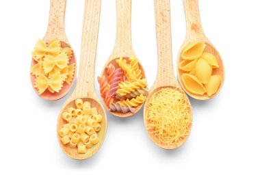 Beyaz arka planda farklı pişmemiş makarna kaşıkları