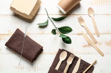 Beyaz ahşap arka planda yiyecek için eko çatal bıçak, fincan ve kap.