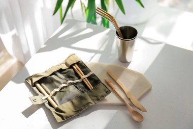 Mutfaktaki masada eko çatal bıçak takımı ve bardak var.