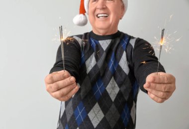 Işık arka planında Noel havai fişekleri olan son sınıf öğrencisi.