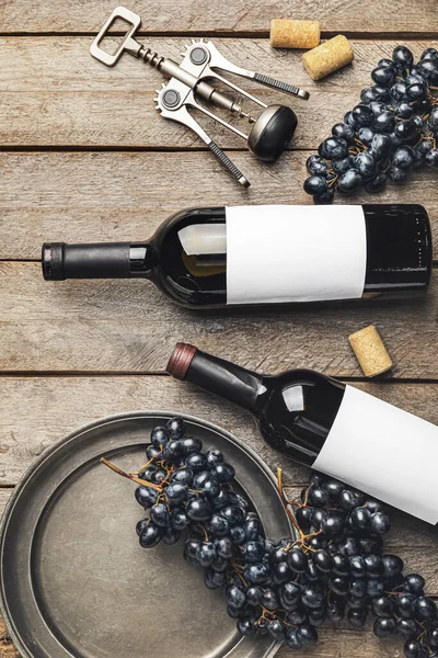 Garrafas Vinho Tinto Com Uvas Frescas Saca Rolhas Fundo Madeira — Fotografia de Stock