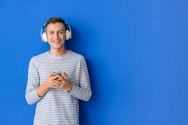 Hombre Joven Con Auriculares Teléfono Móvil Sobre Fondo Color — Foto de Stock