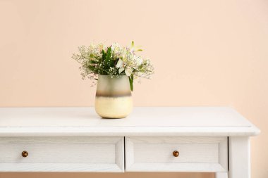 Masada bir buket çiçekli güzel vazo.