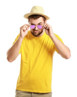 Beyaz arka planda şık güneş gözlüklü yakışıklı bir adam.