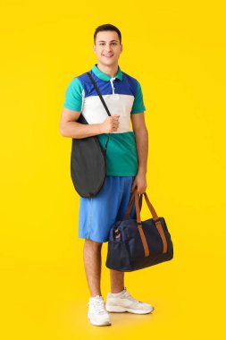 Renkli arka planda çanta ve tenis raketi olan genç bir sporcu.