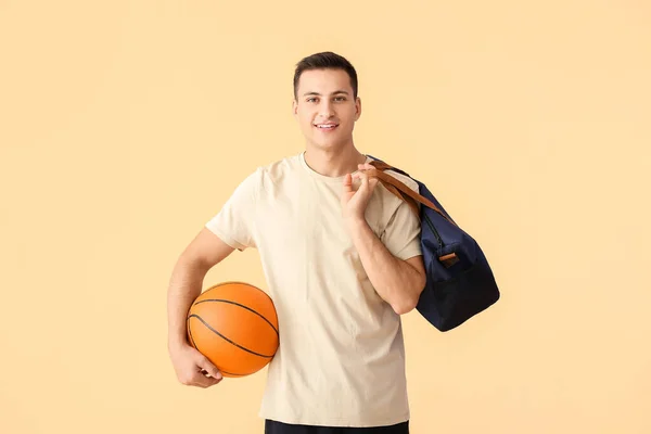 Sportlicher Junger Mann Mit Tasche Und Ball Auf Farbigem Hintergrund — Stockfoto