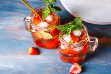 Mason kavanozları taze çilekli mojito kokteyli ahşap masada.