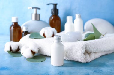 Renkli arkaplanda banyo aksesuarları, kozmetik ürünleri ve pamuk çiçekleriyle kompozisyon