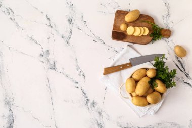 Hafif arka planda çiğ patatesli kompozisyon