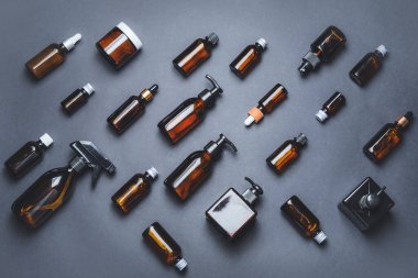 Esmer arka planda kozmetik şişeleri olan kompozisyon