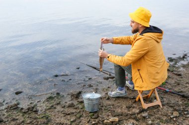 Genç adam nehirde balık tutuyor.