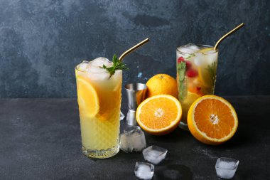 Gri arka planda bir bardak turuncu mojito.